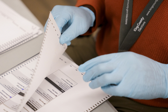 17일(현지시간) 미국 워싱턴주 킹카운티 선거관리위원회 직원이 장갑을 끼고 일하고 있다. (렌턴<워싱턴주> AP=연합뉴스)